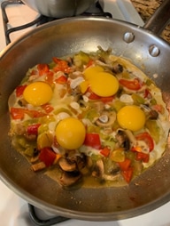 Topping sauteed veggies with eggs